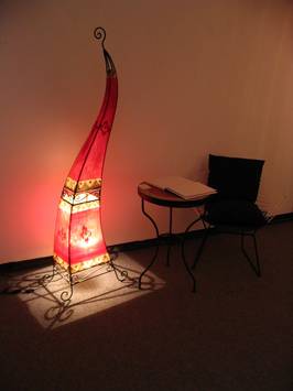 Foto der Ausstellung: Eine verziehrte, orientalische Lampe erhellt den Raum in rötlichem Licht.