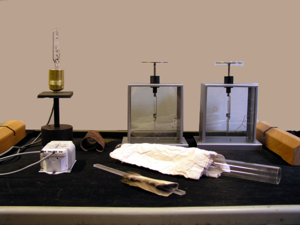 Foto des Versuchsaufbaus mit einer Quecksilberdampflampe, zwei Elektroskopen und Versuchsmaterial.