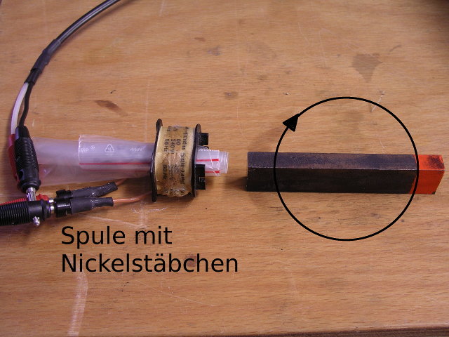 Foto eines Nickelstäbchens in einer Spule mit Dauermagnet davor.