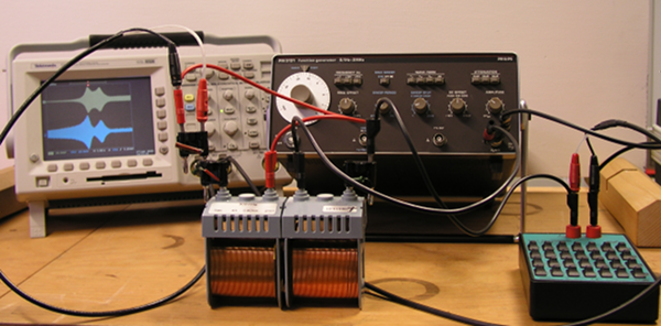 Versuchsaufbau mit Oszilloskop, zwei Spulen, Frequenzgenerator und Widerstandsdekade.