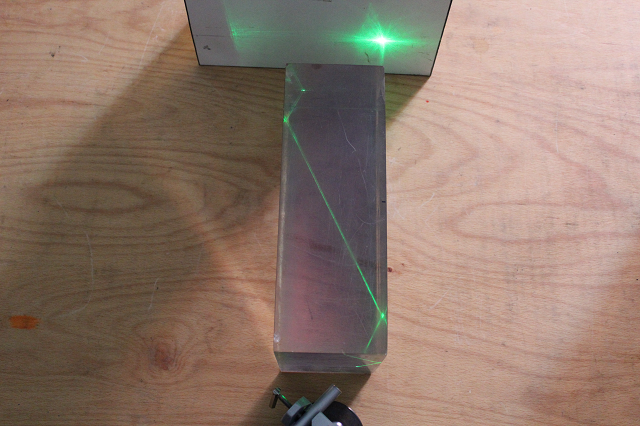 Blick auf einen Kunstharzblock in dem ein Laserstrahl totalreflektiert wird.