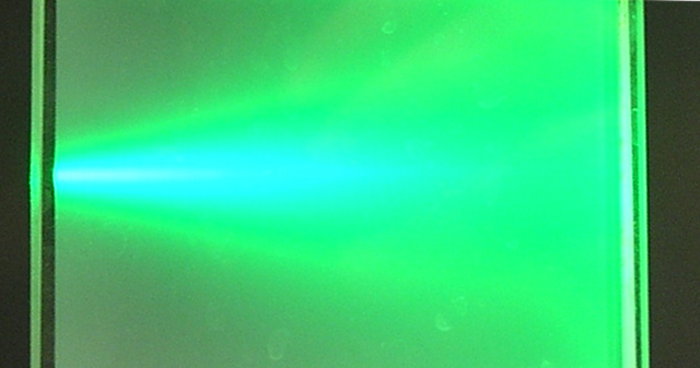 Foto eines Laserstrahls der in Wasser mit wenig Milch gestreut wird.