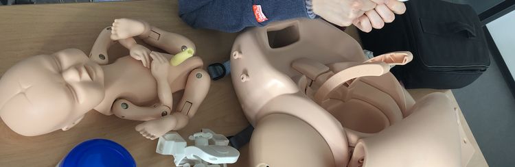 Studierende üben den Geburtsvorgang am Modell