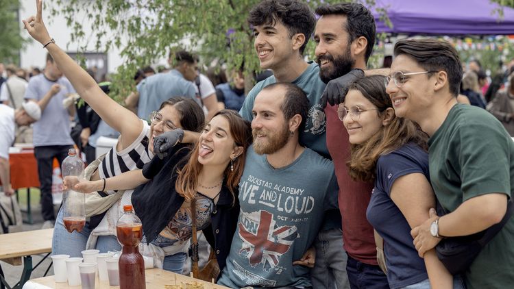 Das Bild zeigt eine Gruppe von Menschen. Sie stehen am Spanien-Stand des Internationalen Sommerfestes und verkaufen Tortillas.