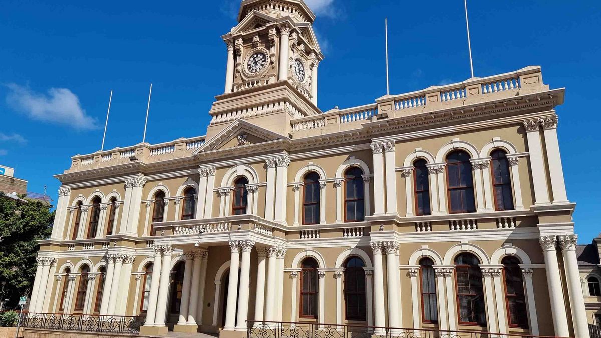 Ein historisches Gebäude mit einer markanten Fassade im neoklassizistischen Stil. 