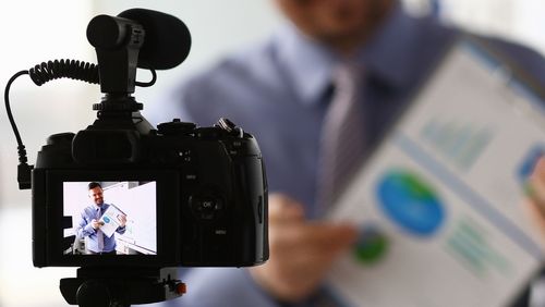 [Translate to English:] man holding a presentation sheet - seen through a camera