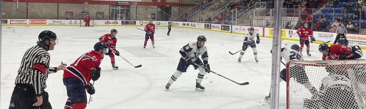 Ice hockey game in a packed arena, players fighting for the puck in front of the goal.