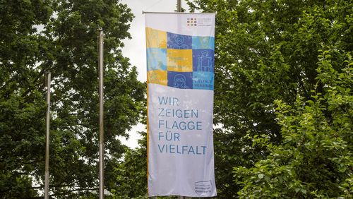 Das Bild zeigt die Flagge der Vielfalt mit dem Slogan "Wir zeigen Flagge für Vielfalt" und dem Logo der Universität Oldenburg.