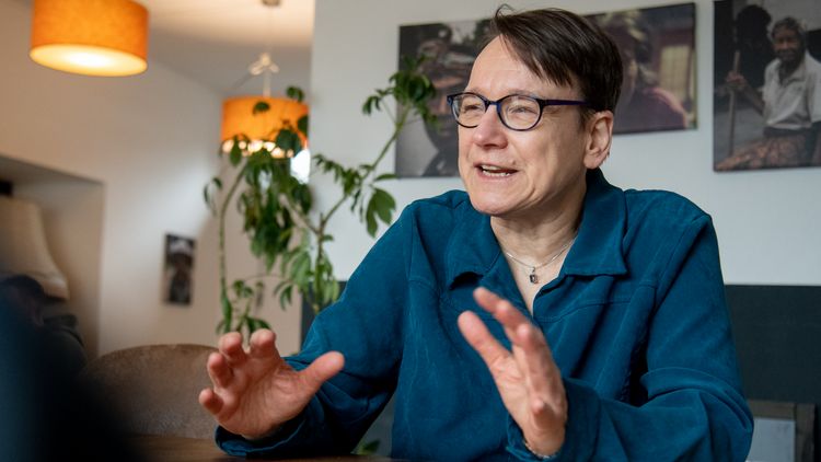 Renate Scheidler is sitting in a café, talking and gesticulating with her hands.