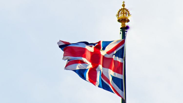 Photo of the Union Jack against a blue sky.