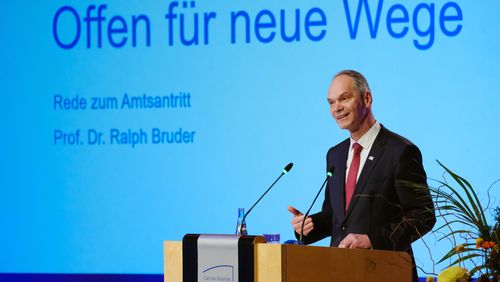 Ralph Bruder gives his inaugural speech, a presentation behind him reads "Open for new ways". 