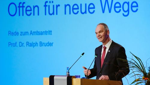 Ralph Bruder hält seine Rede zum Amtsantritt, auf einer Präsentation hinter ihm steht "Offen für neue Wege".