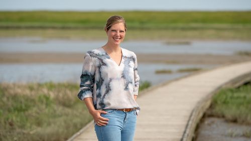 Scientist Leena Karrasch on a footbridge leading across salt marshes.