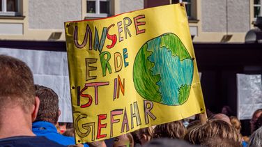 The picture was taken at a demonstration organised by the Fridays for Future movement. In the centre is a large, self-painted poster with a globe that reads: Our earth is in danger. 