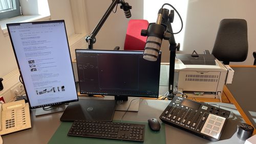 Schreibtisch mit Equipment, um einen Podcast aufzunehmen