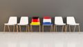 Sechs Stühle, von denen einer die Farben der deutschen und einer der niederändischen Flagge hat.