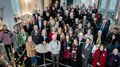 The picture shows the members of the senates and university management of both universities in a large group picture. The camera is positioned slightly above them so that everyone is looking slightly upwards. A buffet can be seen in the background.