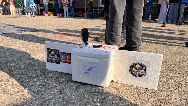 Weiße Styroporbox mit darauf befestigter Kamera und Logo der Astro-AG