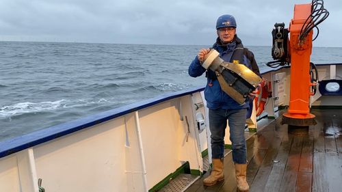 Thomas Badewien stands on a boat with drifter