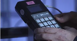 Two hands hold a measuring device that measures magnetic fields
