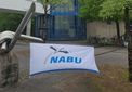 Das Bild zeigt ein Banner mit dem NABU-Logo, dass auf dem Vorplatz vor dem Hörsaalgebäude aufgespannt ist.