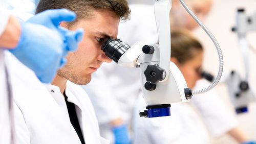 Medizinstudent blickt durch ein Mikroskop