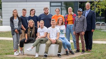 Gruppenbild mit zwölf Personen, vor dem Studierenden Service Center. 