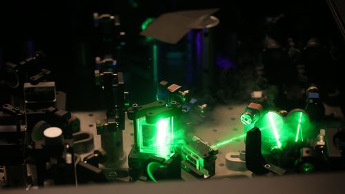Green laser beam in the dark with prisms.