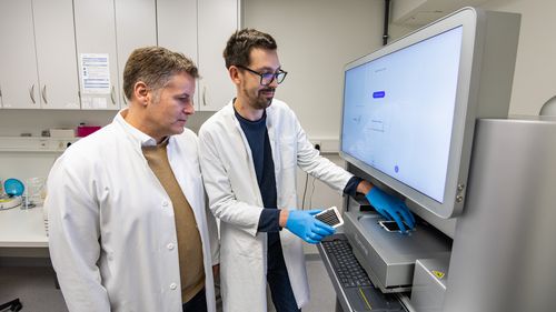 Human geneticists Hitz and Dombrowsky at the sequencing machine in Oldenburg Hospital.
