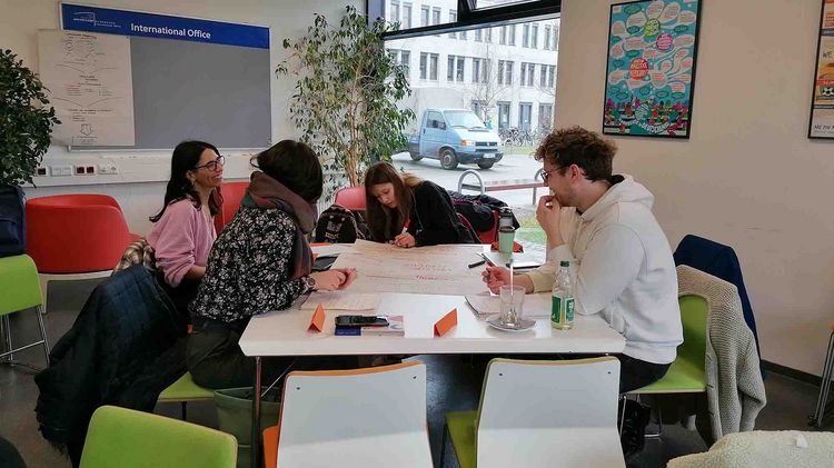 A group of four people sits in the IKT of the University of Oldenburg and attends a training session.