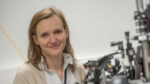 Portraitfoto mit unscharfen Versuchsaufbauten im Vordergrund.