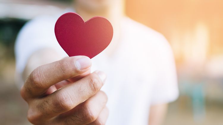 A cut-out heart in her hand.