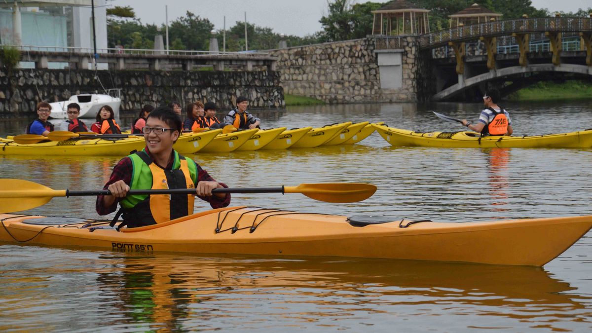 A group of students go kayaking on a lake or river.