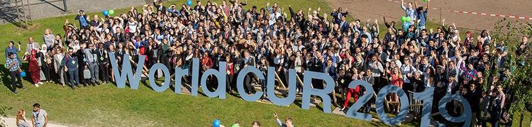 Vogelperspektive auf die Teilnehmende auf dem WorldCUR 2019 hinter dem WorldCUR Logo