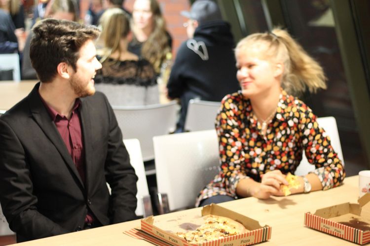 Zwei Studierende essen Pizza