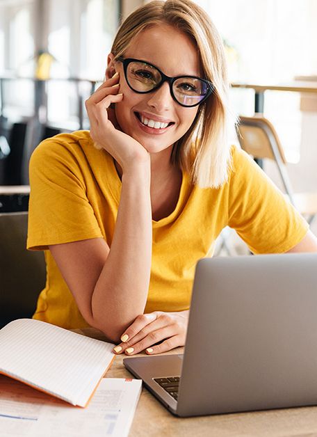 The picture shows two women. One woman is writing information on a whiteboard while the other woman looks on with interest.