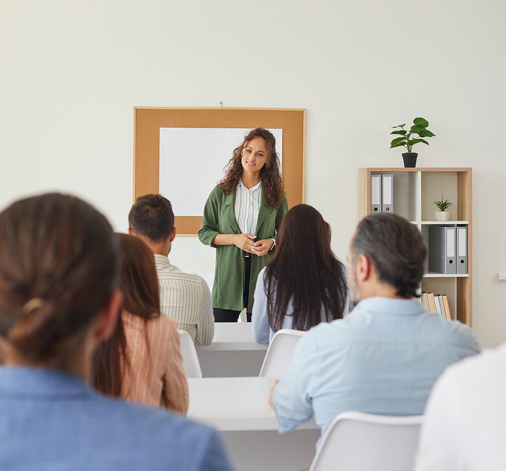 Lehrerin hört sich die Antworten auf ihre Fragen im Unterricht für erwachsene Schüler an. 