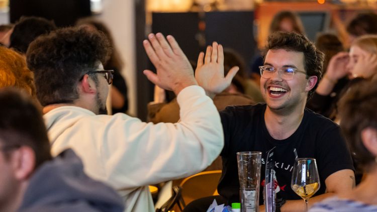 Zwei Quiz-Teilnehmer geben sich lachend High Five.