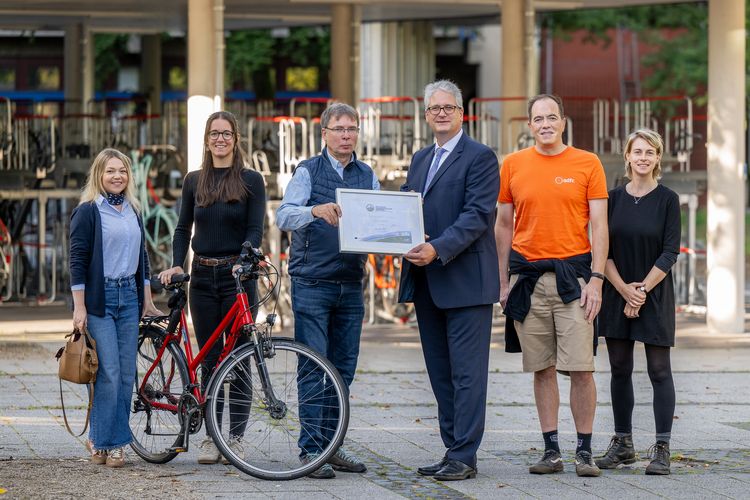 ADFC auditor Uwe Schmidt (3rd from left) presents Jörg Stahlmann, Vice President for Administration and Finance, with the "Bicycle-Friendly Employer" certificate. With them (from left): Ajana Behrend, building management, Anna Krämer, advisor climate protection management, Wolf Wiegand, board member of ADFC Oldenburg, Kikan Nelle, advisor climate protection management specialising in everyday mobility.