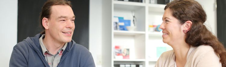 Eine Beratungssituation. Zwei Personen unterhalten sich.