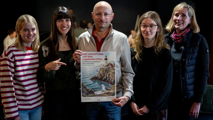 Gruppenbild mit vier Frauen und einem Mann, der ein Plakat hält. 
