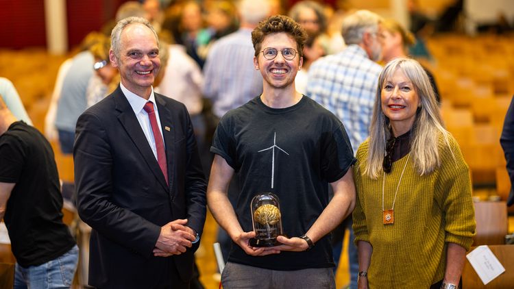 Three people are smiling at the camera.