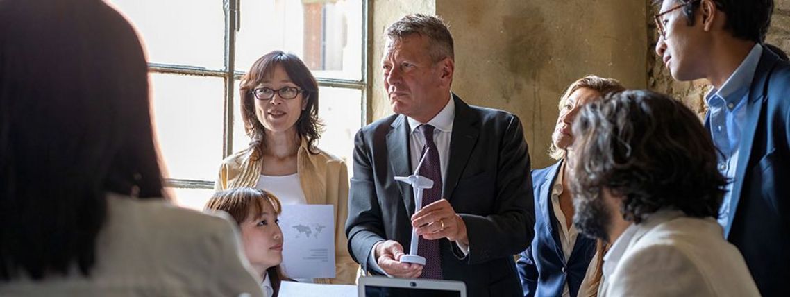 Führungskraft bespricht Windenergie mit diversem Team