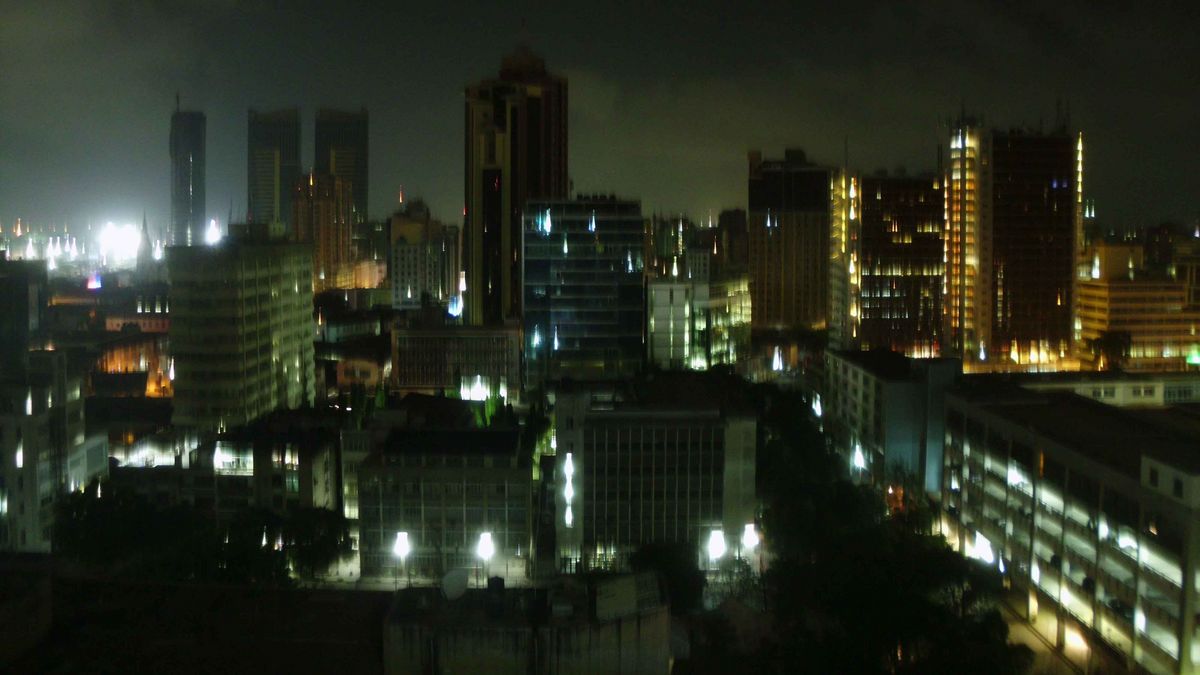 Eine nächtliche Skyline von Dar es Salaam, Tansania, mit hohen Gebäuden und Lichtern.