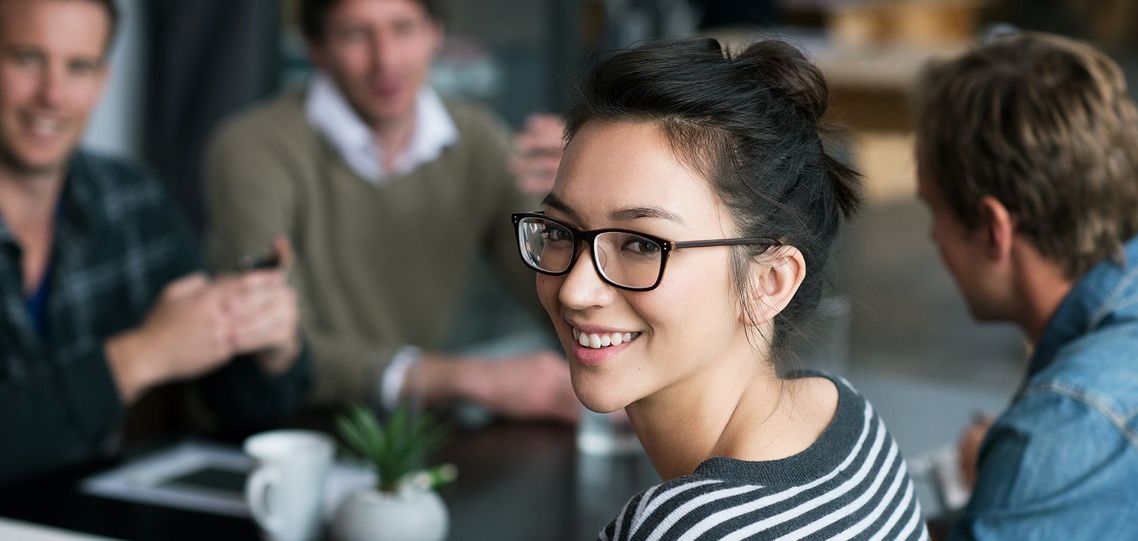 Auf dem Bild sind vier glückliche und zufriedene Menschen zu sehen, welche die Zielgruppe der Weiterbildung repräsentieren.