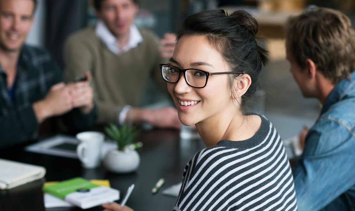 The picture shows four happy and satisfied people who represent the target group for further education.
