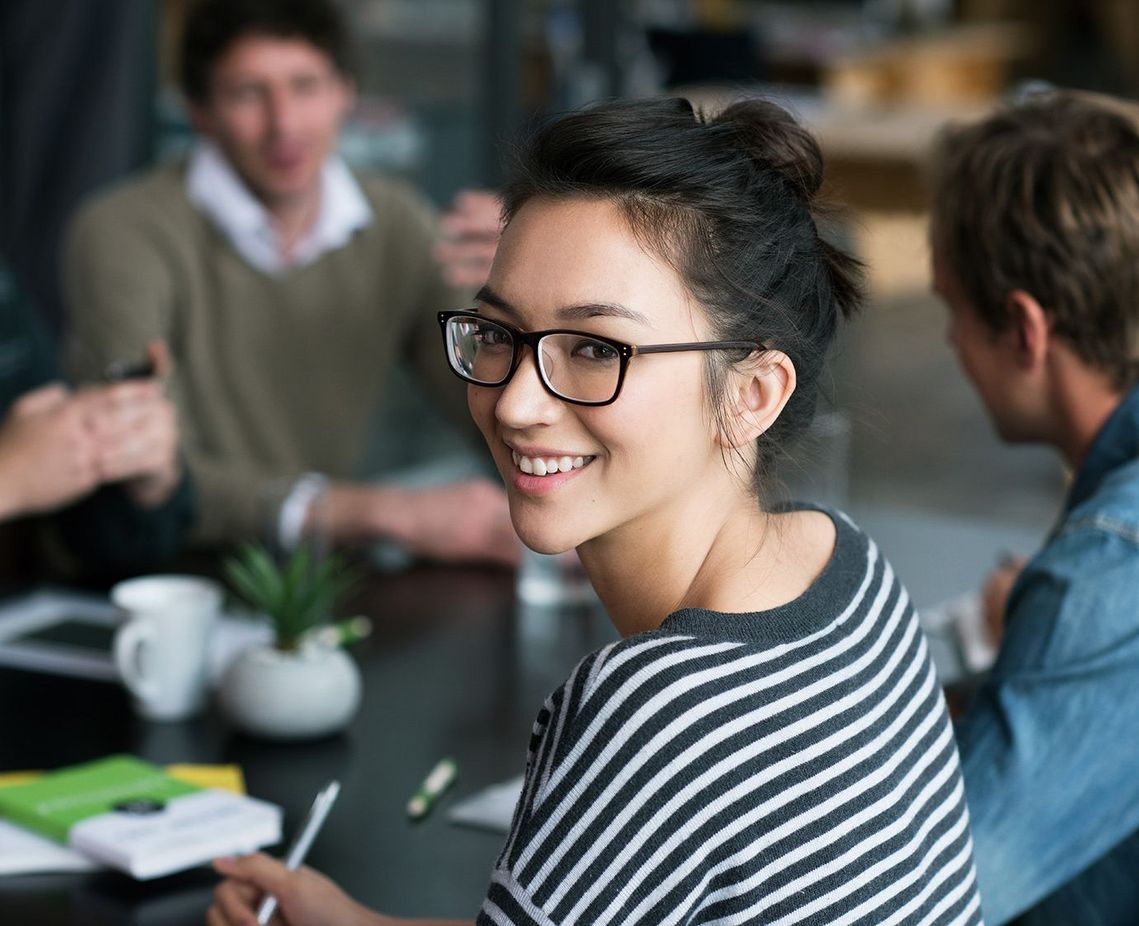 Auf dem Bild sind vier glückliche und zufriedene Menschen zu sehen, welche die Zielgruppe der Weiterbildung repräsentieren.
