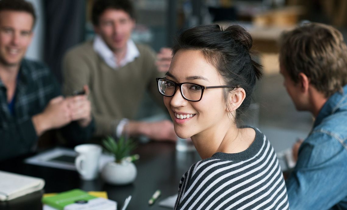 Auf dem Bild sind vier glückliche und zufriedene Menschen zu sehen, welche die Zielgruppe der Weiterbildung repräsentieren.