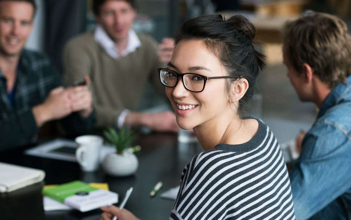 Auf dem Bild sind vier glückliche und zufriedene Menschen zu sehen, welche die Zielgruppe der Weiterbildung repräsentieren.