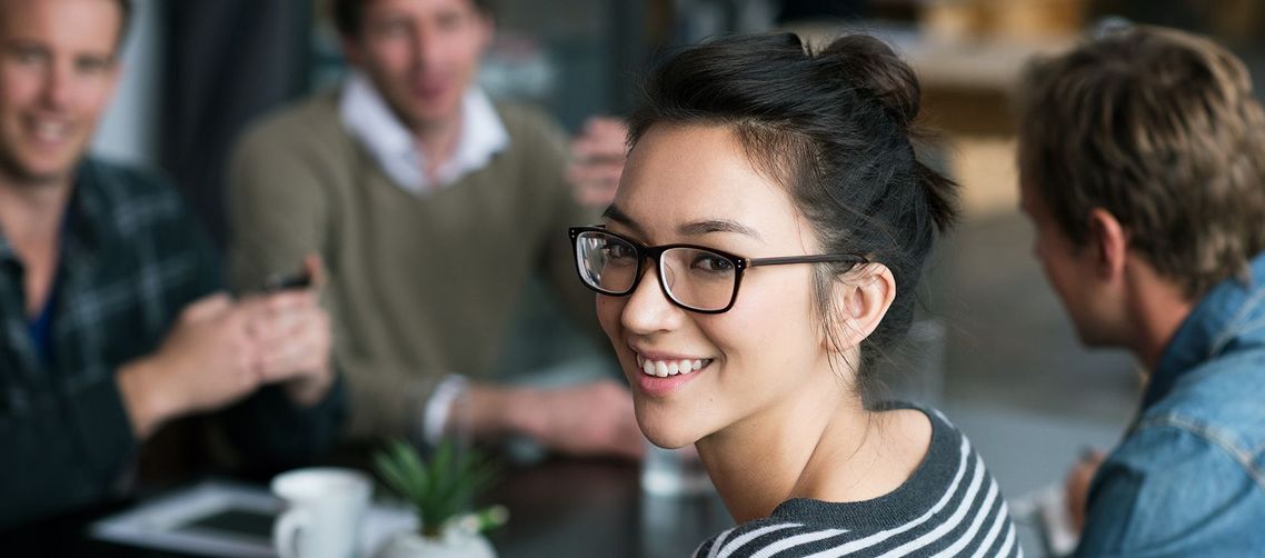 Auf dem Bild sind vier glückliche und zufriedene Menschen zu sehen, welche die Zielgruppe der Weiterbildung repräsentieren.